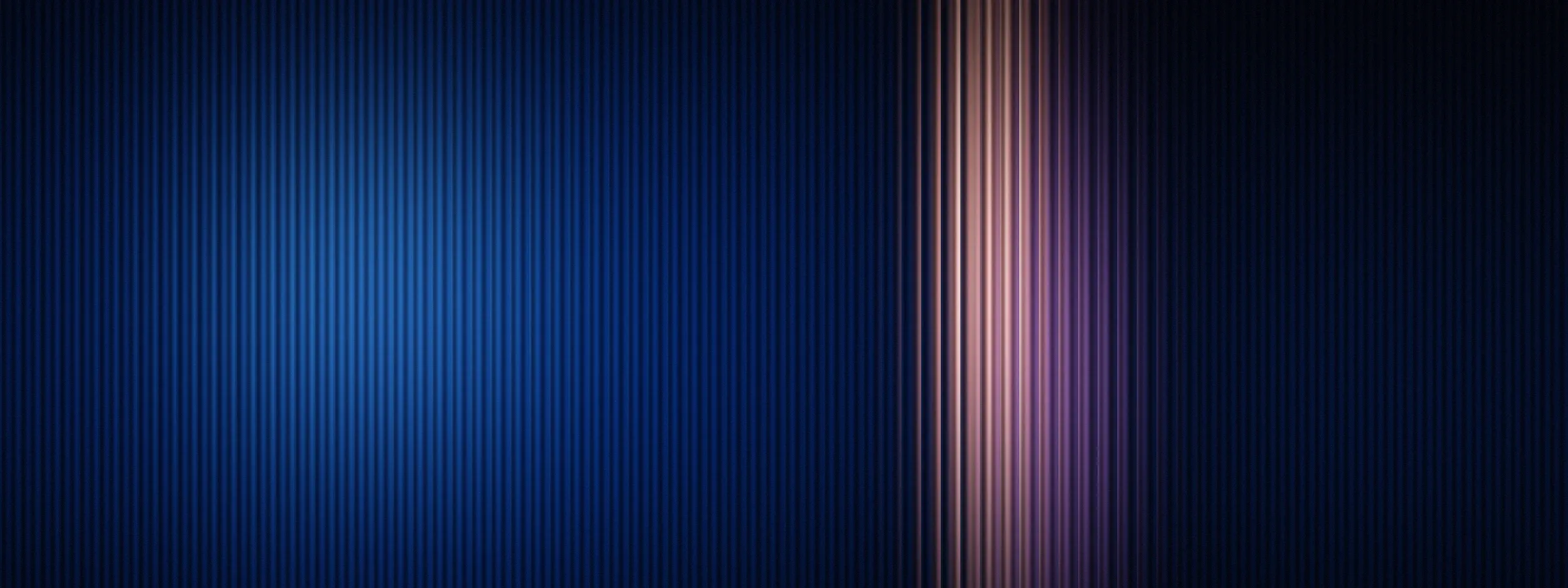 A single warm beam of light standing apart from cool blue light behind reeded glass, illustrating brand positioning