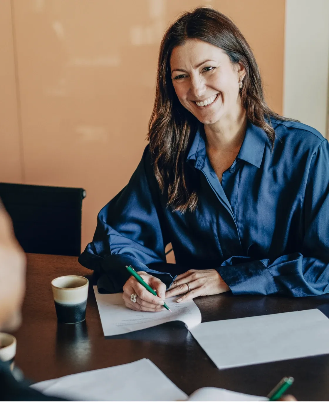 Smiling professional taking notes at a desk