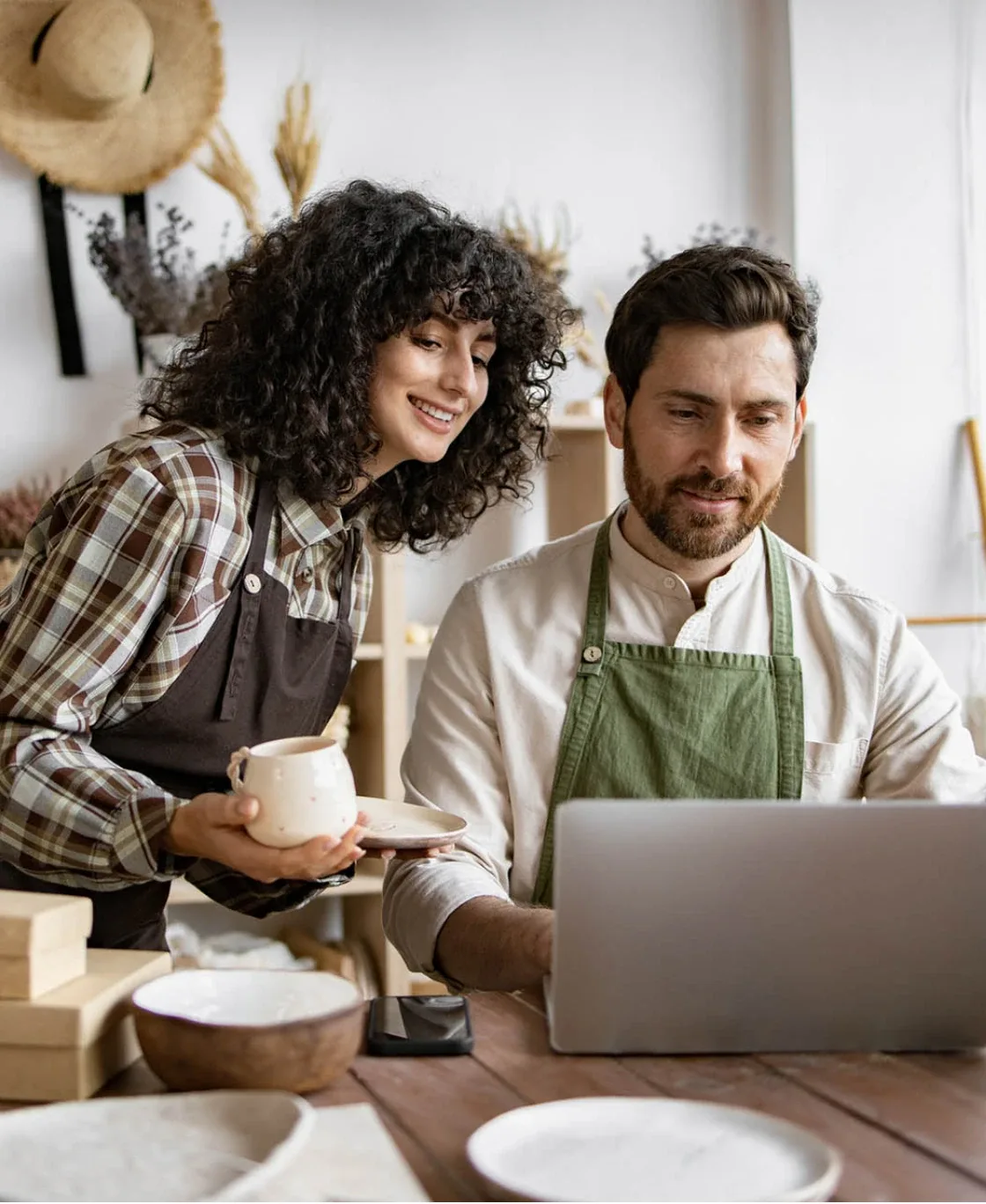 Two small business owners reviewing work on a laptop