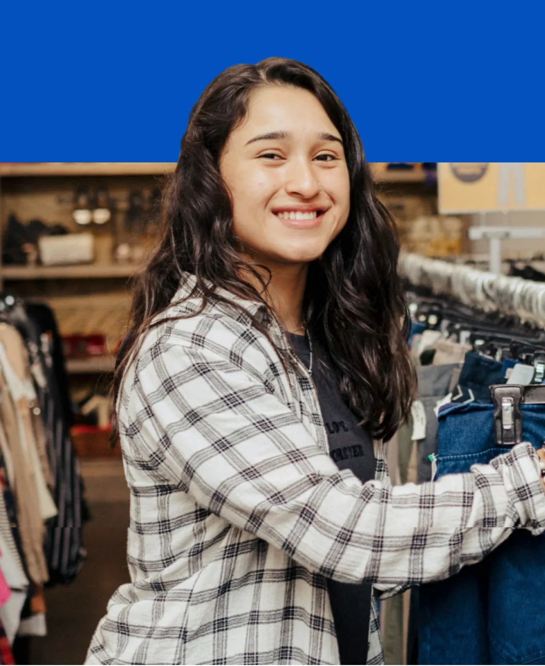 Smiling young woman browsing clothes in a Goodwill store