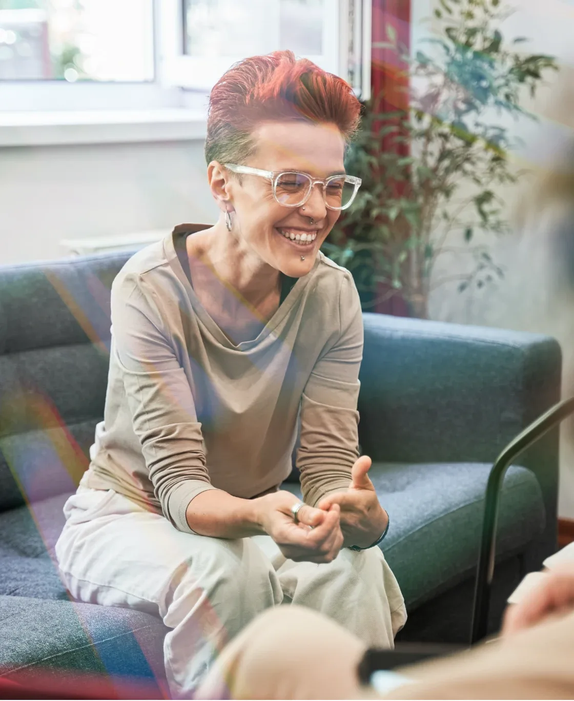 Smiling woman in glasses sitting on a sofa