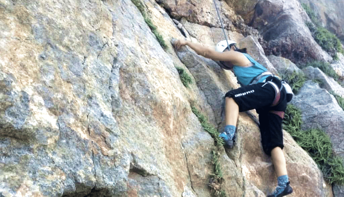 A woman climbing a mountain