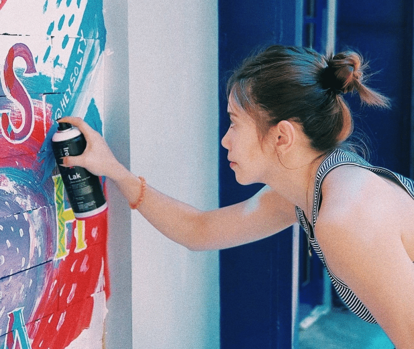 a woman spray painting the wall