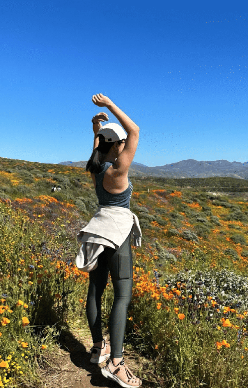 A woman streching herself while hiking on a mountain